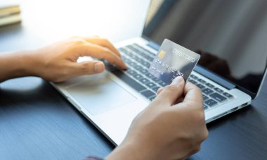 İş adamları internet üzerinden kredi kartı ödemelerini, teknoloji ve İnternet 'te rahatlığı, online alışveriş ve online bankacılık kavramını kullanarak online alışverişleri kaydetmek için dizüstü bilgisayar kullanıyorlar..