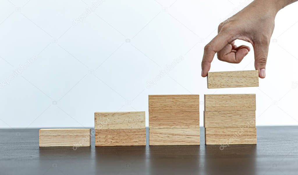Arrange the wooden blocks into steps, higher the marketing strategy the more effort is required, Driving business at the peak concept.
