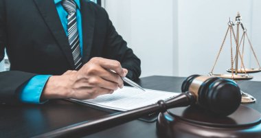 Yargıç ya da avukat mahkeme salonunda belgeler üzerinde çalışır ve adalet, doğruluk, dava ve adalet kavramları için çeşitli yasaları analiz eder..