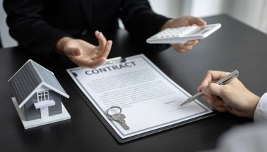 Emlakçı ev satın alma anlaşmasının şartları hakkında konuştu ve müşteriden sözleşmeyi yasal hale getirmek için belgeleri imzalamasını istedi, ev satışları ve ev sigortası kavramı.