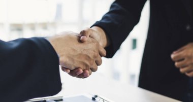 Selamlama ve toplantı, iş ortakları olarak el sıkışarak birbirlerini tebrik etmek gayrimenkul yatırımında arkadaşlık kurmak, el sıkışma konsepti..