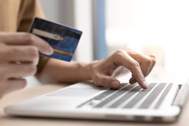 Çevrimiçi ürün alımı, İşadamı çevrimiçi alışveriş kavramı, çevrimiçi alışverişler yapmak için kredi kartlarıyla dizüstü bilgisayarı kullanır.