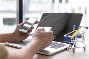 İş adamı, uygulamalar, çevrimiçi alışveriş veya İnternet teknolojisi konsepti yoluyla çevrimiçi ürün satın almak için kredi kartıyla çevrimiçi güvenlik için cep telefonu kullanıyor.