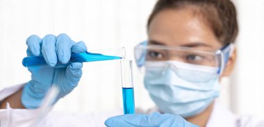 Bilim insanları kimyasal bileşimin ve biyolojik kütlesinin bilimsel bir laboratuvarda, bilim adamlarında ve laboratuar konseptinde tespit edilmesine hazırlanmak için mavi kimyasal test tüpleri taşıyorlar..