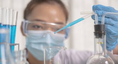 Bilim insanları kimyasal bileşimin ve biyolojik kütlesinin bilimsel bir laboratuvarda, bilim adamlarında ve laboratuar konseptinde tespit edilmesine hazırlanmak için mavi kimyasal test tüpleri taşıyorlar..