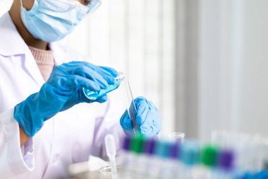 Bilim insanları kimyasal bileşimin ve biyolojik kütlesinin bilimsel bir laboratuvarda, bilim adamlarında ve laboratuar konseptinde tespit edilmesine hazırlanmak için mavi kimyasal test tüpleri taşıyorlar..