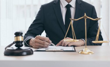 Yargıç ya da avukat mahkeme salonunda belgeler üzerinde çalışır ve adalet, doğruluk, dava ve adalet kavramları için çeşitli yasaları analiz eder..