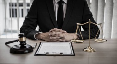 Yargıç ya da avukat mahkeme salonunda belgeler üzerinde çalışır ve adalet, doğruluk, dava ve adalet kavramları için çeşitli yasaları analiz eder..