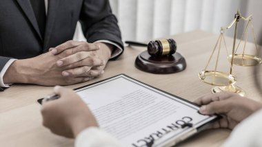 Avukatlar veya danışmanlar mahkeme salonunda çalışır ve şirket dolandırıcılığı, dava ve adalet kavramlarında adalet isteyen müvekkillerle veya şikayetçilerle pazarlık ederler..
