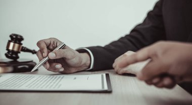 Mahkeme salonunda çalışan avukat veya danışmanlar şu anda şirketin yolsuzluk davalarını soruşturuyor ve müvekkillerine hukuki onay, dava ve adalet kavramını imzalatıyorlar..