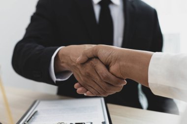 Avukatlar veya danışmanlar, davanın şirket, müzakere veya davaların çözümü konsepti tarafından sona erdirilmesini kutlamak için müvekkillerle el ele tutuşuyor..