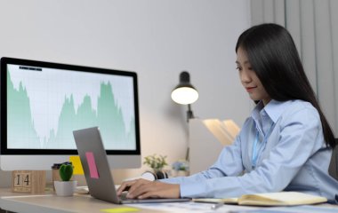 Asyalı kadın internet üzerinden neşeli bir gülümsemeyle çalışıyor, evde kalıyor, Yeni Normal, Covid-19 Coronavirus, Sosyal Mesafe, İnternet Öğrenimi.