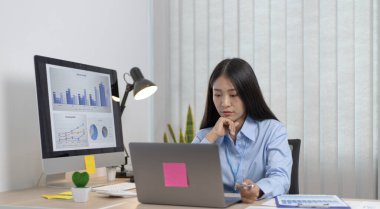 Asyalı kadın internet üzerinden neşeli bir gülümsemeyle çalışıyor, evde kalıyor, Yeni Normal, Covid-19 Coronavirus, Sosyal Mesafe, İnternet Öğrenimi.