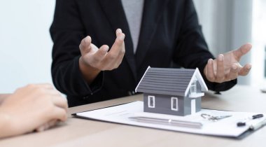 Emlakçılar müşterilerine sigortalı bir ev alma kararı almalarını öneriyor. Satın alma ve yatırım planlama konsepti pazarlığı.