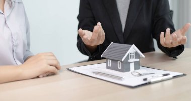 Emlakçılar müşterilerine sigortalı bir ev alma kararı almalarını öneriyor. Satın alma ve yatırım planlama konsepti pazarlığı.