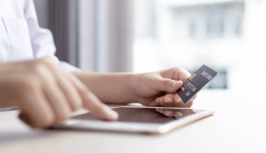 İşadamı, uygulamalar, online alışveriş veya İnternet teknolojisi konsepti yoluyla çevrimiçi ürün satın almak için kredi kartıyla güvenlik için tablet kullanıyor.