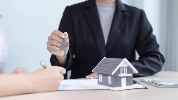 不動産エージェントは クライアントに送信するための鍵を保持し 顧客に住宅販売契約と住宅保険に署名するための条件を提供しています 住宅販売と住宅保険の概念 — ストック写真