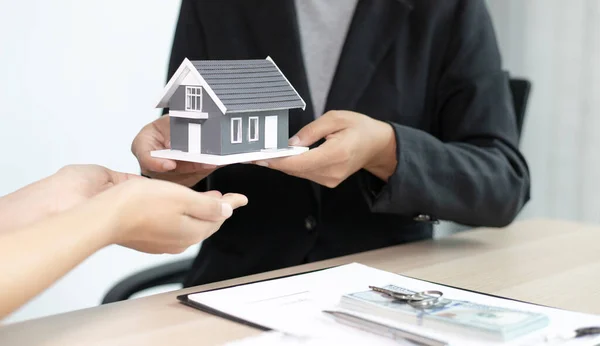 住宅販売業者または不動産業者は 住宅購入契約に署名した顧客のための家を受け取り 購入販売と投資計画の概念を交渉する — ストック写真