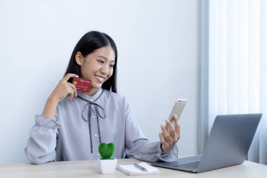 Genç kadınlar internetten alışveriş yapmaktan ve internet üzerinden ödeme yapmak için internet üzerinden kredi kartı tutmaktan, internet üzerinden alışveriş ve kredi kartı ödemelerinden mutlular..