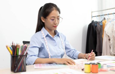 Asyalı moda tasarımcıları modern çağa uygun yeni giyim tarzları yaratıyorlar, yeni bir kıyafet koleksiyonu yaratıyorlar, tasarımcının çalışmalarının yaratımı.