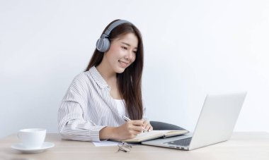 Asyalı kadın evinde dizüstü bilgisayarıyla çalışıyor, evde kalıyor, Yeni Normal, Covid-19 Coronavirus, Sosyal Mesafe, İnternet Öğrenimi.