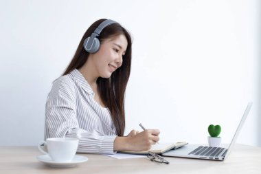 Asyalı kadın evinde dizüstü bilgisayarıyla çalışıyor, evde kalıyor, Yeni Normal, Covid-19 Coronavirus, Sosyal Mesafe, İnternet Öğrenimi.