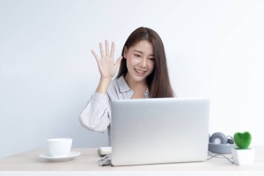 Genç Asyalı kadınlar video sohbetleri yoluyla arkadaşlarını ve öğretmenlerini selamlıyor ve onları neşeli ifadelerle karşılıyor, Online iletişim, Evde kal, Yeni Normal, Covid-19 Coronavirus, Sosyal Mesafe, İnternet Öğrenimi.
