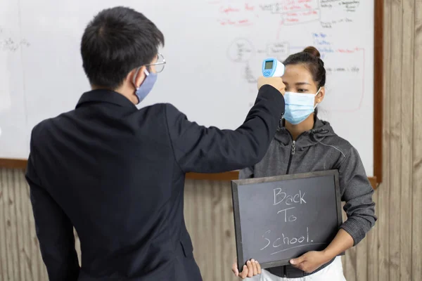 선생님들은 고열이 사람의 측정하고 새로운 독감이 퍼지는 피하기 학생의 체온을 — 스톡 사진