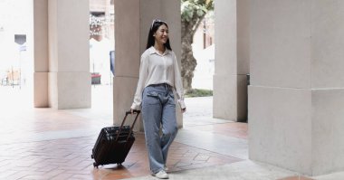 Tatilde seyahat etmek için siyah bavul taşıyan Asyalı kadın, Trolley çanta, uzun haftasonu seyahati, geziyi seviyorum, turizm festivali konseptini seviyorum.