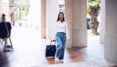 Tatilde seyahat etmek için siyah bavul taşıyan Asyalı kadın, Trolley çanta, uzun haftasonu seyahati, geziyi seviyorum, turizm festivali konseptini seviyorum.