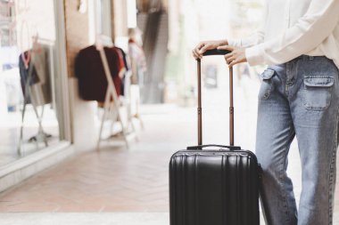 Yılın tatilinde seyahat etmek için büyük siyah bir çanta taşıyan Asyalı kadın, Trolley çanta, uzun haftasonu seyahati, geziye bayılıyorum, turizm festivali konseptine bayılıyorum..