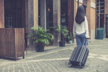 Tatilde seyahat etmek için siyah bavul taşıyan Asyalı kadın, Trolley çanta, uzun haftasonu seyahati, geziyi seviyorum, turizm festivali konseptini seviyorum.