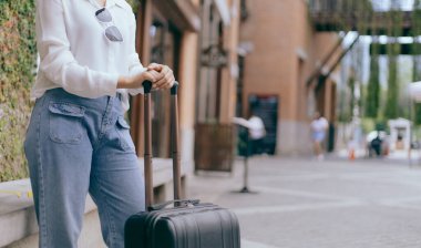 Yılın tatilinde seyahat etmek için büyük siyah bir çanta taşıyan Asyalı kadın, Trolley çanta, uzun haftasonu seyahati, geziye bayılıyorum, turizm festivali konseptine bayılıyorum..