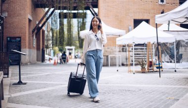 Tatilde seyahat etmek için siyah bavul taşıyan Asyalı kadın, Trolley çanta, uzun haftasonu seyahati, geziyi seviyorum, turizm festivali konseptini seviyorum.