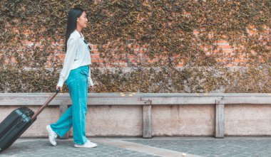 Tatilde seyahat etmek için siyah bavul taşıyan Asyalı kadın, Trolley çanta, uzun haftasonu seyahati, geziyi seviyorum, turizm festivali konseptini seviyorum.