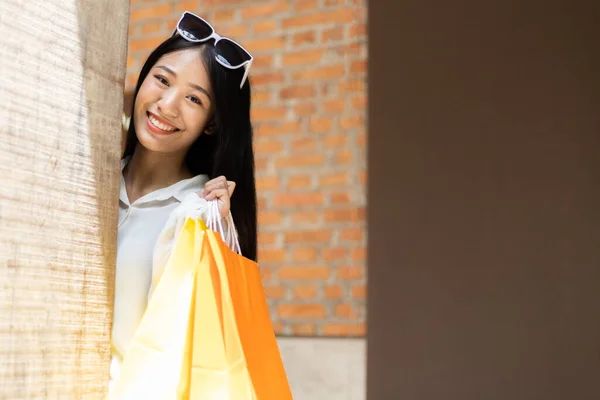 Young Asian women happily carry colorful shopping bags to shop in the mall or shopping center, Sale day, Happy shopping concept.