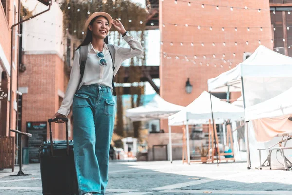 Asian woman beaming carrying a suitcase black to travel on vacation, Trolley bag, Long weekend travel, Love the trip, Tourism festival concept.