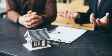 Emlakçı ya da satış müdürü ev satışları teklif etti ve ev satın alma sözleşmesi ve ücretsiz ev sigortası, finans ve satış sonrası hizmet kavramını açıkladı..