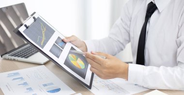 Finans işadamları şirketin kâr ve büyüme, piyasa araştırma raporları ve gelir istatistikleri, Finansal ve Muhasebe kavramı yaratma performansının grafiğini analiz ediyor.