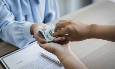 İşadamları, yasadışı arazi ve gayrimenkul, iş dolandırıcılığı ve sosyal adaletsizlik, yolsuzluk ve rüşvet kavramını satın almak için sözleşmeler imzalayan çalışanlara dolar dağıtıyor.