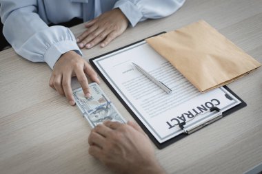 İşadamları, yasadışı arazi ve gayrimenkul, iş dolandırıcılığı ve sosyal adaletsizlik, yolsuzluk ve rüşvet kavramını satın almak için sözleşmeler imzalayan çalışanlara dolar dağıtıyor.