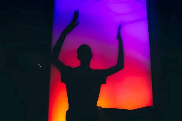 Dancing silhouette of man at the techno party