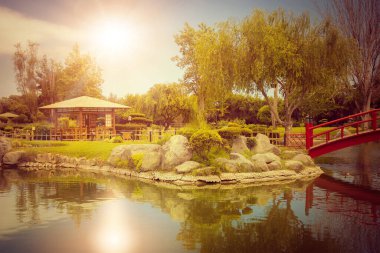 Şili, La Serena 'da gün batımında gölde yansımaları olan güzel Japon bahçesi.