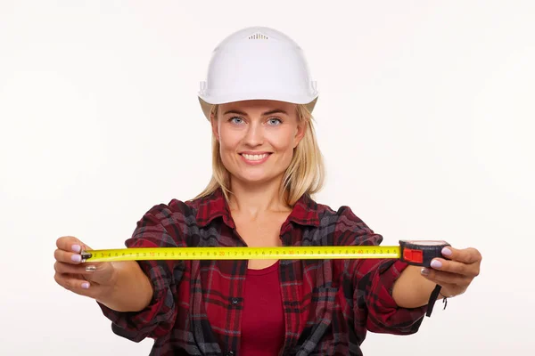 白い建設ヘルメットと黄色のテープメジャーを持つ赤いシャツの女の子 — ストック写真