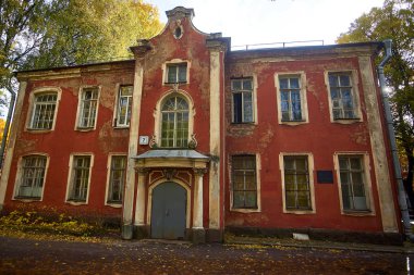 Ağaçların arasında, parkta eski kırmızı bir ev.