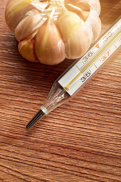 the thermometer is on the table in the background of garlic