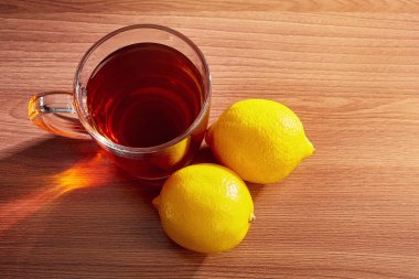 Masanın üzerinde limonlu bir fincan çay.