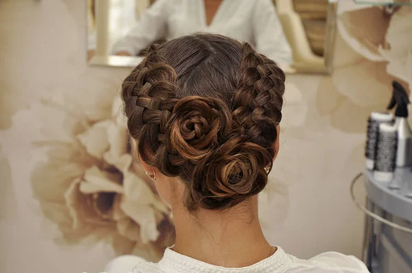 Beautiful wedding hairstyle. The bride's hairstyle in the beauty salon. Rear view.