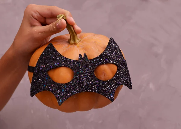 Halloween pumpkin head. Pumpkin head in a bat mask.