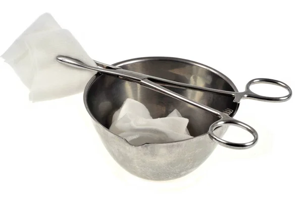 Stainless steel bowl, compresses and medical clip close up on white background